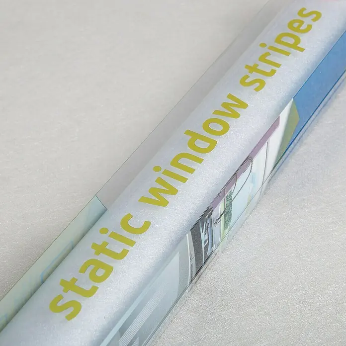 D-c-fix StaticStripes Glasfolie Ava - 200 x 30 cm, Transluzent, Statisch haftend - Nahaufnahme von statischen Fensterstreifen in einer durchsichtigen Verpackung. Die gelbe Beschriftung ist gut sichtbar.