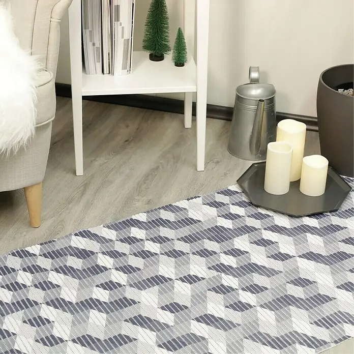 D-c-fix Bodenmatte Floor Comfort - Curtis, 200 x 65 cm - Nahaufnahme eines modernen blauen und weißen Teppichs mit geometrischem Würfelmuster, der dem Raum einen stilvollen Touch verleiht.