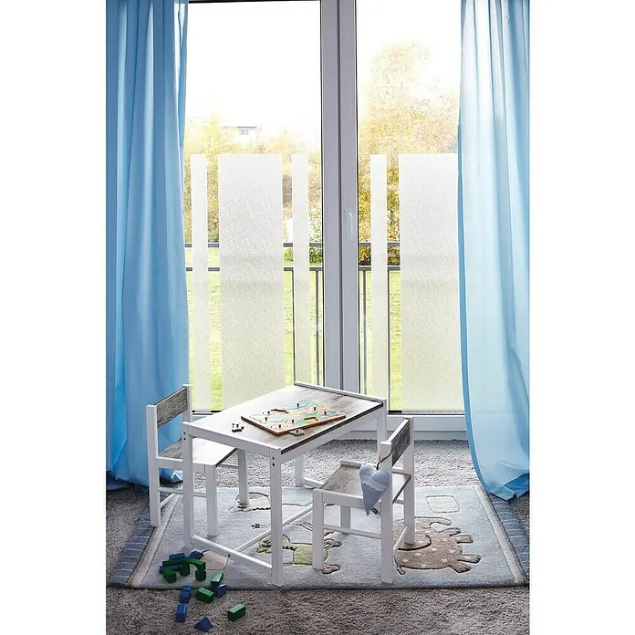 D-c-fix StaticStripes Glasfolie Ava - 200 x 45 cm, Transluzent, Statisch haftend - Kindersitzgruppe mit Tisch und Stühlen auf einem Teppich mit Tiermotiven, vor einem Fenster mit Vorhängen.