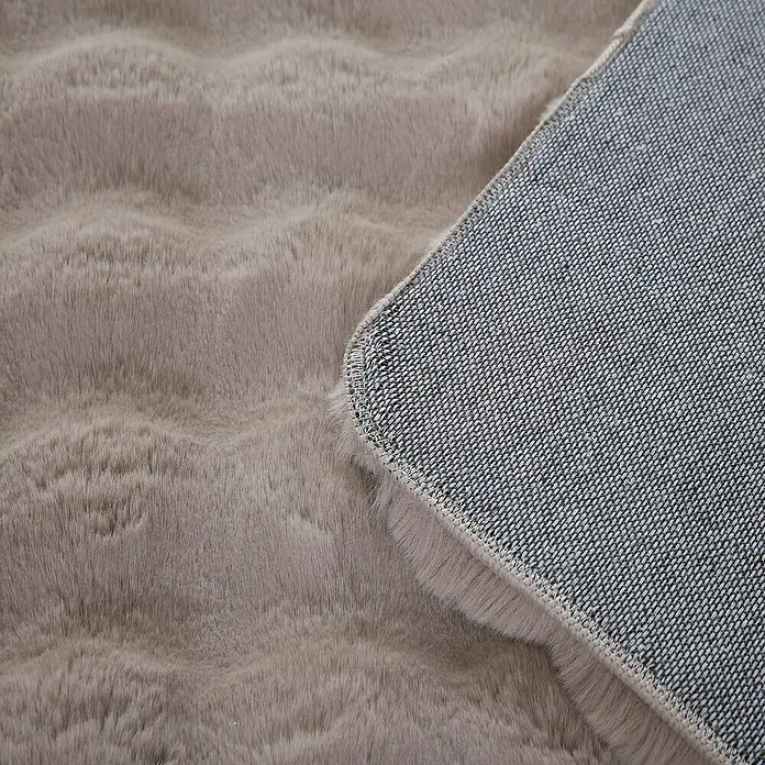 Fellteppich Ambiance - Beige, 200 x 140 cm, 100 % Polyester - Nahaufnahme eines flauschigen, grauen Teppichs mit gewebter Unterseite.