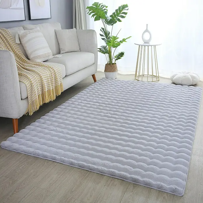 Fellteppich Ambiance - Silber, 250 x 80 cm, 100 % Polyester - Ein weicher, grauer Teppich mit gewellter Oberfläche liegt in einem hellen Wohnzimmer und verleiht dem Raum eine gemütliche Atmosphäre.
