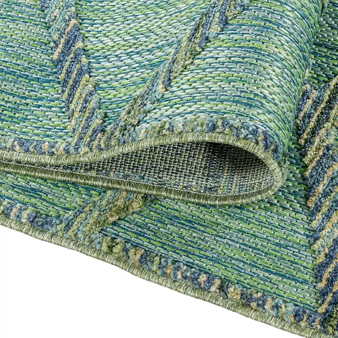 Outdoor-Teppich Bahama III - Grün, 250 x 80 cm, 100 % Polypropylen - Ein teilweise gerollter, grün-blauer Teppich mit Chevron-Muster, Webstruktur und Fransen.