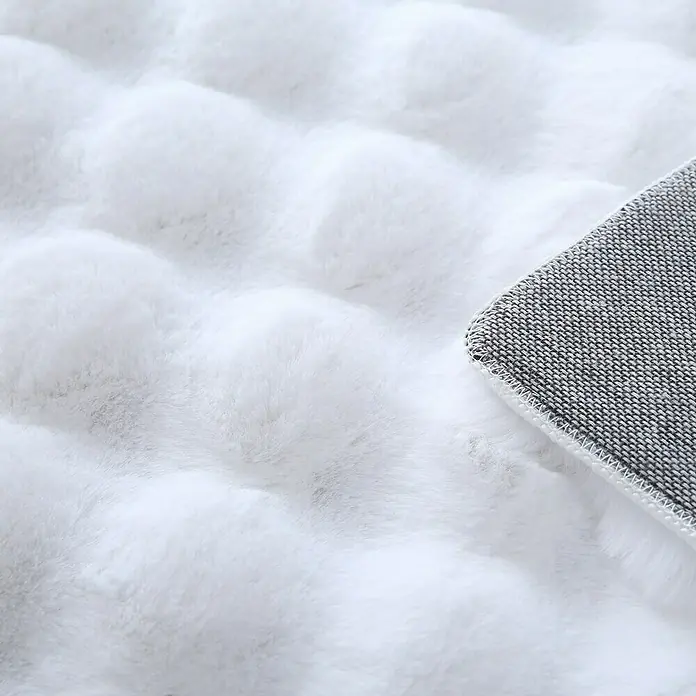 Fellteppich Ambiance - Weiß, 250 x 80 cm, 100 % Polyester - Nahaufnahme eines weichen, weißen Teppichs mit Noppenstruktur und grauer Unterseite.