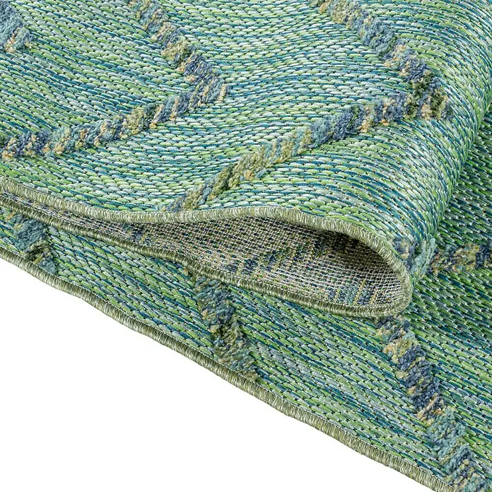 Outdoor-Teppich Bahama IV - Grün, 250 x 80 cm, 100 % Polypropylen - Detailansicht eines blau-grünen Teppichs mit Zickzackmuster, aufgerollt, der seine Textur und das Design hervorhebt.