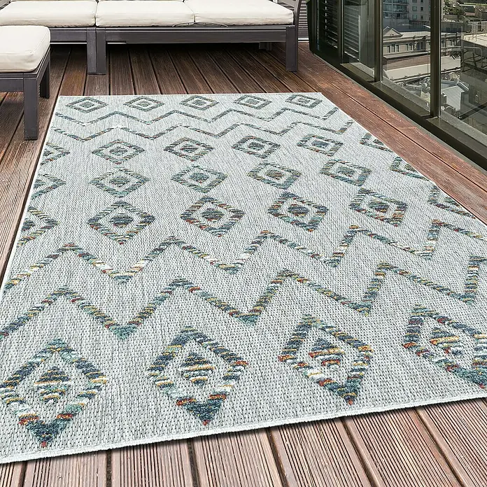 Outdoor-Teppich Bahama IV - Multi, 200 x 140 cm, 100 % Polypropylen - Nahaufnahme eines strukturierten Outdoor-Teppichs mit geometrischen Mustern auf einer Holzterrasse.