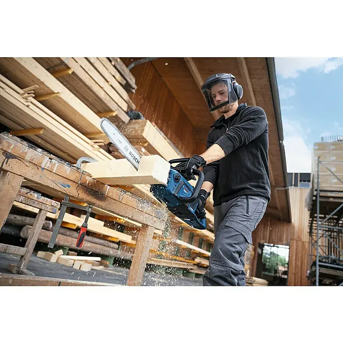 Bosch Professional AMPShare 18V Akku-Kettensäge GKE 18V-40 - 18 V, Li-Ionen, Ohne Akku, Schwertlänge: 40 cm - Ein Mann sägt mit einer Bosch Akku-Kettensäge ein Holzbrett. Die Säge ist blau und hat eine weiße Kette. Er trägt Schutzkleidung.