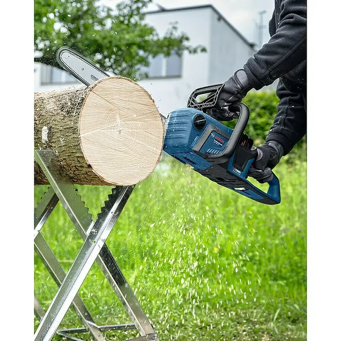 Bosch Professional AMPShare 18V Akku-Kettensäge GKE 18V-40 - 18 V, Li-Ionen, Ohne Akku, Schwertlänge: 40 cm - Nahaufnahme einer Bosch Akku-Kettensäge beim Holzsägen, die die Leistung und Präzision des Werkzeugs hervorhebt.
