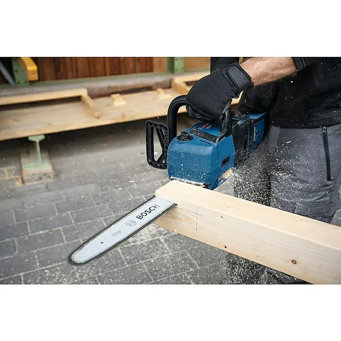 Bosch Professional AMPShare 18V Akku-Kettensäge GKE 18V-40 - 18 V, Li-Ionen, Ohne Akku, Schwertlänge: 40 cm - Nahaufnahme einer Bosch-Akku-Kettensäge beim Sägen eines Holzstücks. Staub und Späne fliegen durch die Luft.