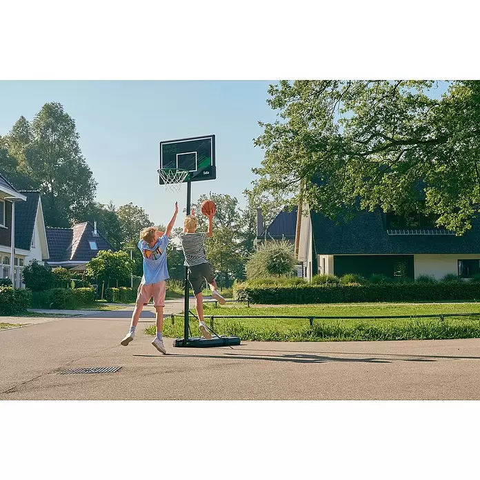 Salta Basketballkorb Forward - L x B x H: 172 x 110 x 362 cm, Schwarz - Zwei Jungen spielen Basketball mit einem schwarzen und grünen tragbaren Salta Basketballkorb im Freien.