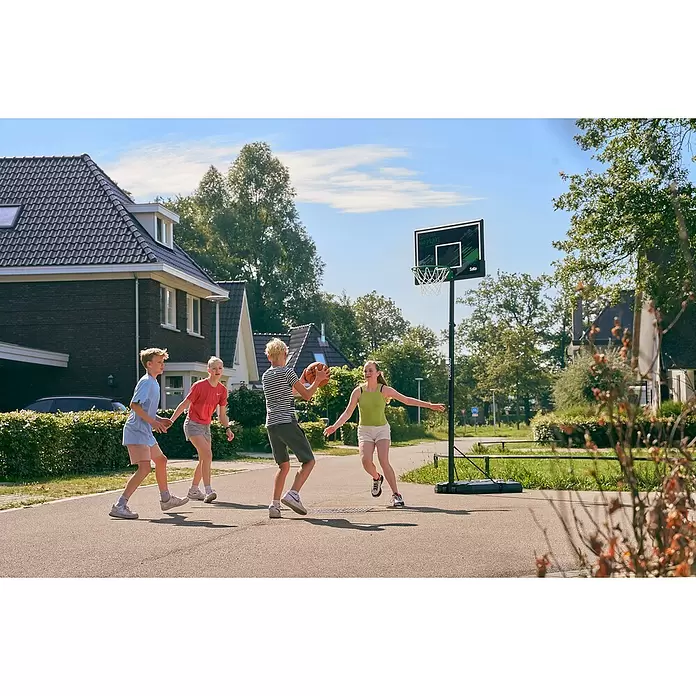 Salta Basketballkorb Forward - L x B x H: 172 x 110 x 362 cm, Schwarz - Kinder spielen Basketball mit einem schwarzen, mobilen Korb mit grünem Akzent und 'COME OUT AND PLAY!'-Rückwand.