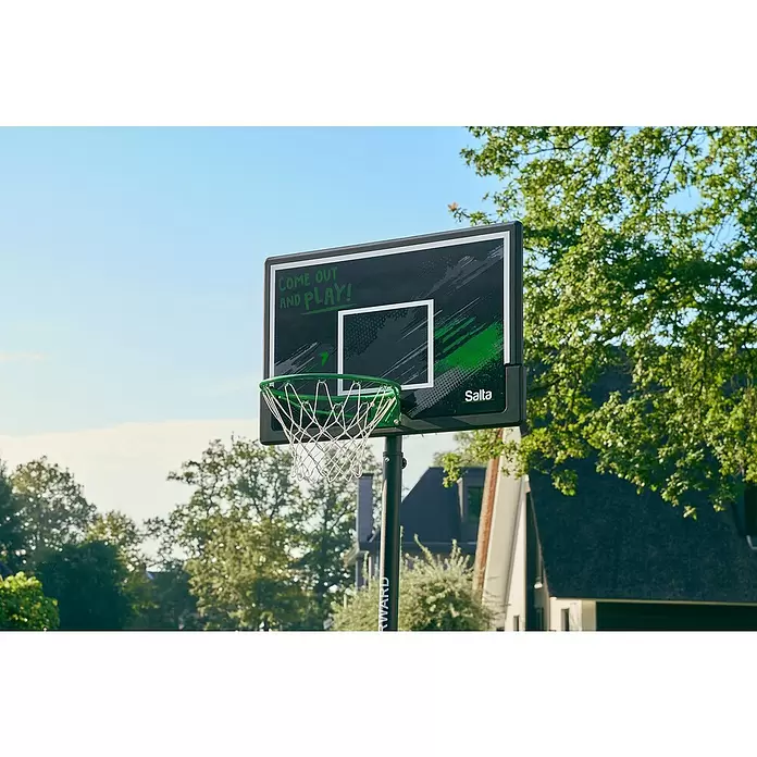 Salta Basketballkorb Forward - L x B x H: 172 x 110 x 362 cm, Schwarz - Schwarzer Basketballkorb mit grünem Ring und Netz, Text „COME OUT AND PLAY!“ auf der Rückwand, draußen vor Bäumen und Himmel.