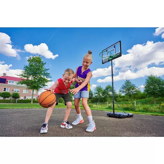 Salta Basketballkorb Dribble - Schwarz - Zwei Kinder spielen draußen mit einem schwarzen, tragbaren Basketballkorb mit grünem Ring und weißem Netz.