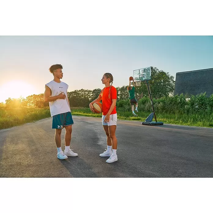 Salta Basketballkorb Guard - Schwarz, Höhe: 371 cm - Junge Leute in Sportkleidung und weißen Turnschuhen spielen draußen Basketball.