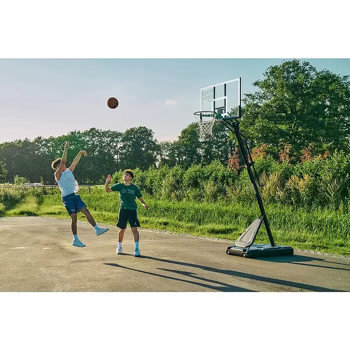 Salta Basketballkorb Guard - Schwarz, Höhe: 371 cm - Zwei junge Männer spielen draußen Basketball mit einem tragbaren Korb mit schwarzem Gestell und klarer Platte.