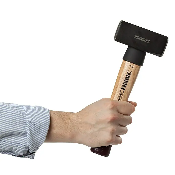 Wisent Fäustel - 1.500 g, Holz Hickory - Bild einer Hand, die einen schweren WISENT Hammer mit Holzgriff hält, ideal für Bau- und Abbrucharbeiten.