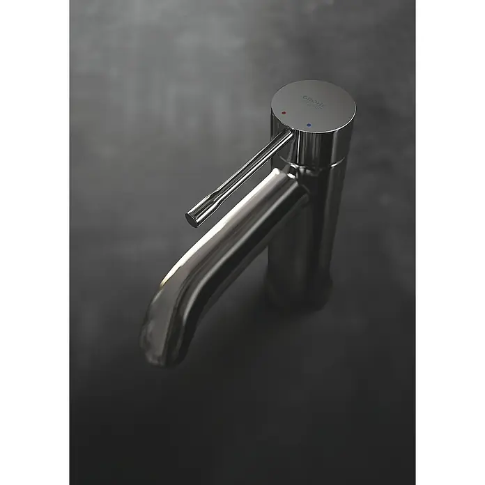 Grohe Essence New Waschtischarmatur S-Size - Mit Zugstange, Hard Graphite, Glänzend - Nahaufnahme einer glänzenden Grohe Armatur auf einem dunklen Hintergrund, die das elegante Design und die hochwertige Verarbeitung hervorhebt.