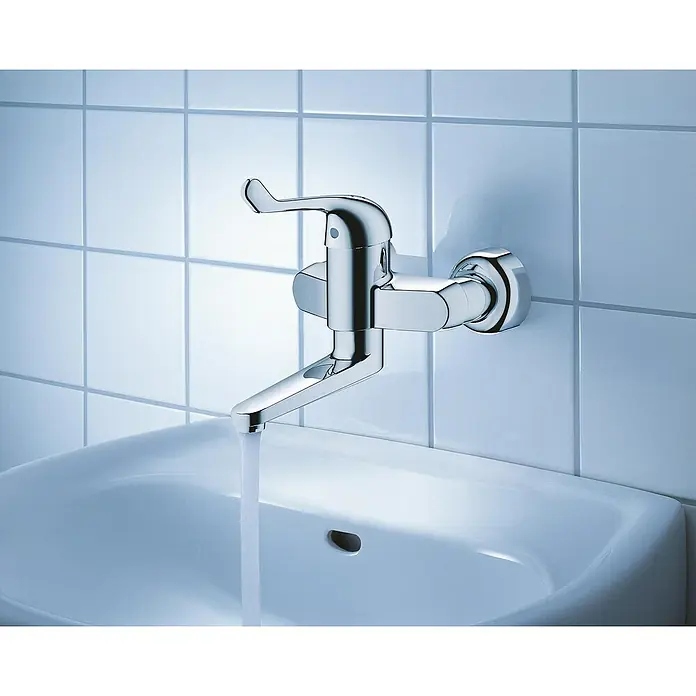 Grohe Euroeco Special Waschtischarmatur - Wandmontage, Chrom, Glänzend, Ausladung Armatur: 197 mm - Ein verchromter Wasserhahn an einer weißen Wand, der Wasser in ein Waschbecken leitet. Der Hahn ist modern und minimalistisch gestaltet.