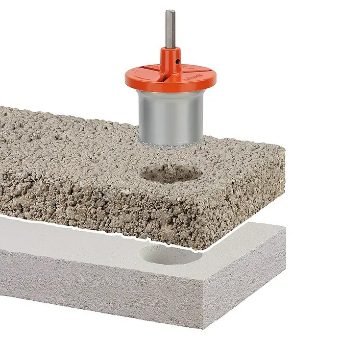 Wolfcraft Bohrkrone - Durchmesser Bohrer: 83 mm - Das Bild zeigt eine Kernbohrmaschine beim Bohren eines Lochs in einen Betonblock. Das Werkzeug ist rot und silberfarben.