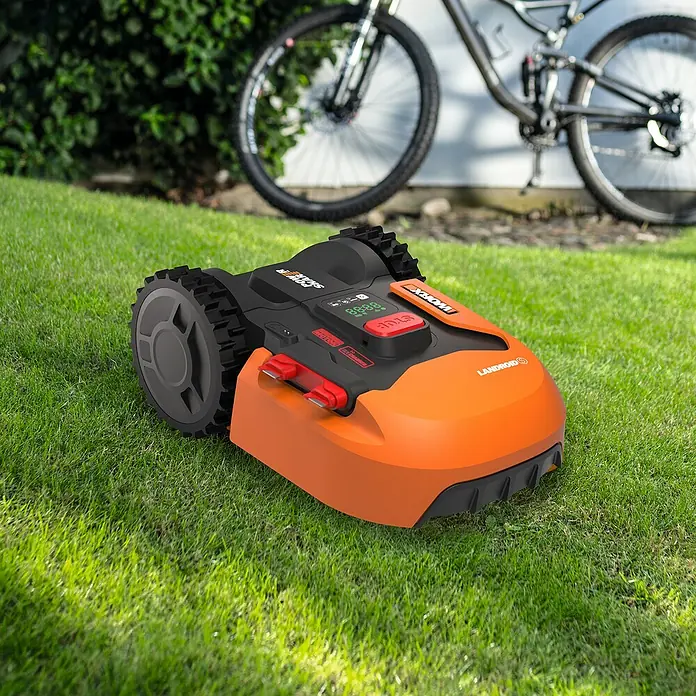 Worx PowerShare 20V Mähroboter Landroid S400 - 400 m², Schnittbreite: 18 cm, Induktionsgestützte Navigation, Begrenzungskabel - Ein orangefarbener Worx Landroid Rasenmähroboter steht auf einem Rasen mit einem Fahrrad im Hintergrund.