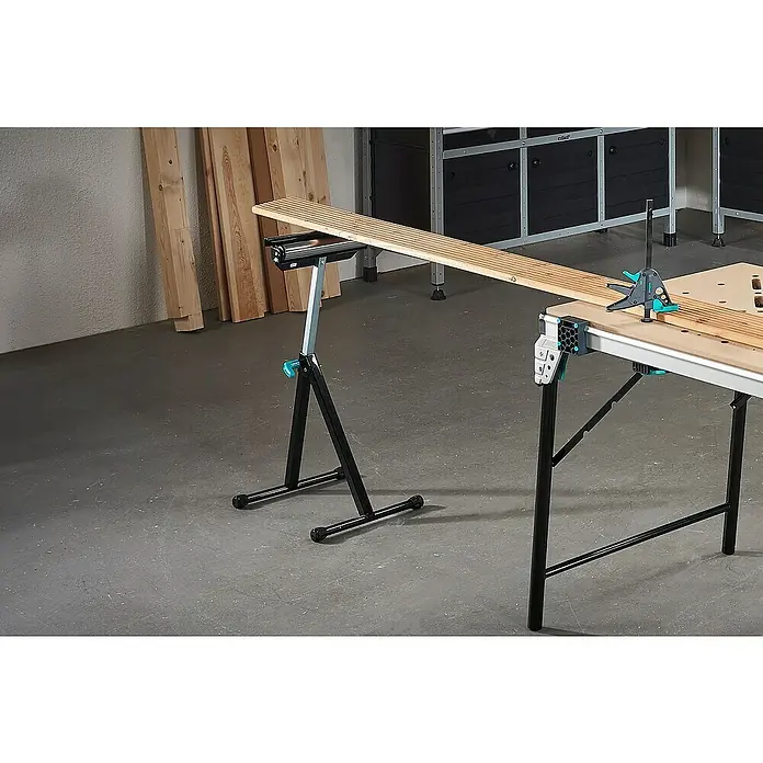 Wolfcraft Multifunktions-Auflagebock - Arbeitshöhe: 630 mm - 1.000 mm, Belastbarkeit: 50 kg - Werkstatteinrichtung mit einem Wolfcraft Arbeitstisch und einer Rollenstütze, die Holzbretter tragen.