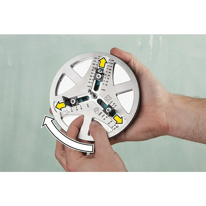 Wolfcraft Lochsäge verstellbar - Arbeitsdurchmesser: 45 mm - 130 mm, Schnitttiefe: 30 mm - Nahaufnahme einer Vorrichtung zum Messen und Markieren von Bohrpunkten in einer Hand, die eine Drehbewegung andeutet.
