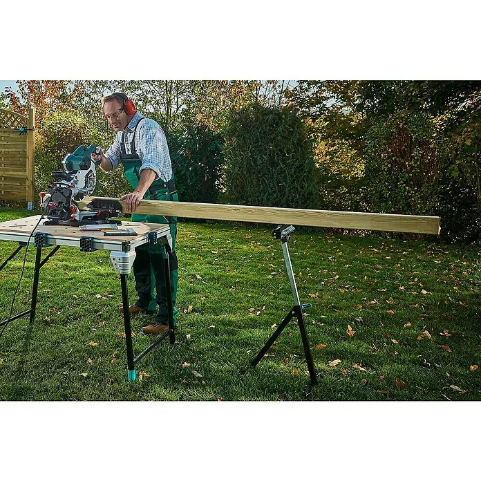 Wolfcraft Multifunktions-Auflagebock - Arbeitshöhe: 630 mm - 1.000 mm, Belastbarkeit: 50 kg - Ein Mann mit Gehörschutz, der einen Holzbalken mit einer Tischkreissäge auf einem Wolfcraft Master Cut 2500 zuschneidet.