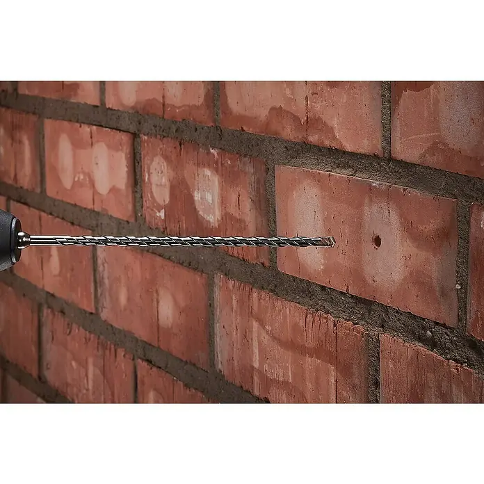 Wolfcraft Beton- & Steinbohrer Standard - Durchmesser Bohrer: 12 mm, Länge: 600 mm - Nahaufnahme eines Bohrers, der ein Loch in eine Ziegelwand bohrt, Hervorhebung der Präzision des Werkzeugs und seiner Anwendung auf Mauerwerk.
