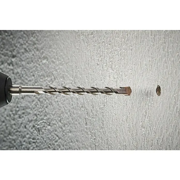 Wolfcraft Beton- & Steinbohrer Standard - Durchmesser Bohrer: 12 mm, Länge: 600 mm - Nahaufnahme eines Bohrers mit einer Spiralnut, der sich einer Wand mit einem kleinen Loch nähert. Werkzeug zum Bohren in harte Oberflächen.