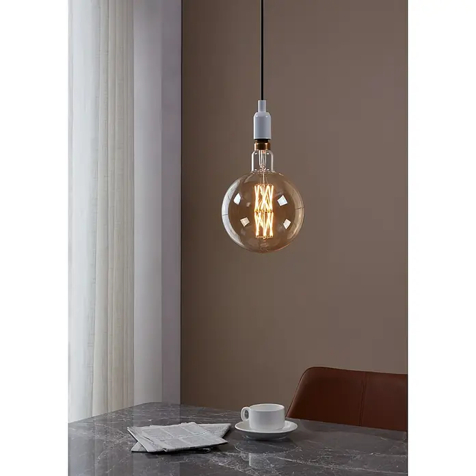 Eglo LED-Lampe - E27, Dimmbar, Warmweiß, 806 lm, 8 W - Stimmungsvolle Hängelampe mit warmem Licht über einem Tisch mit Zeitung und Kaffeetasse, die eine gemütliche Atmosphäre erzeugt.