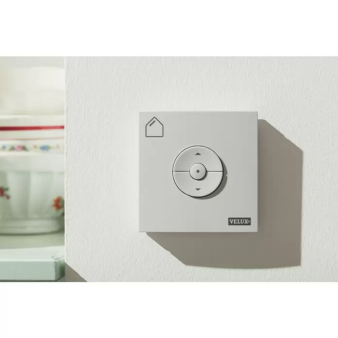 Velux Funk-Wandschalter Sonnenschutz KLI 312 - Passend für: Innen liegende VELUX Solar- & Elektro-Sonnenschutzprodukte (io-homecontrol®) - Graues Velux Wandbedienfeld mit runder Richtungstaste und Haussymbol für Smart-Home-Funktionen.