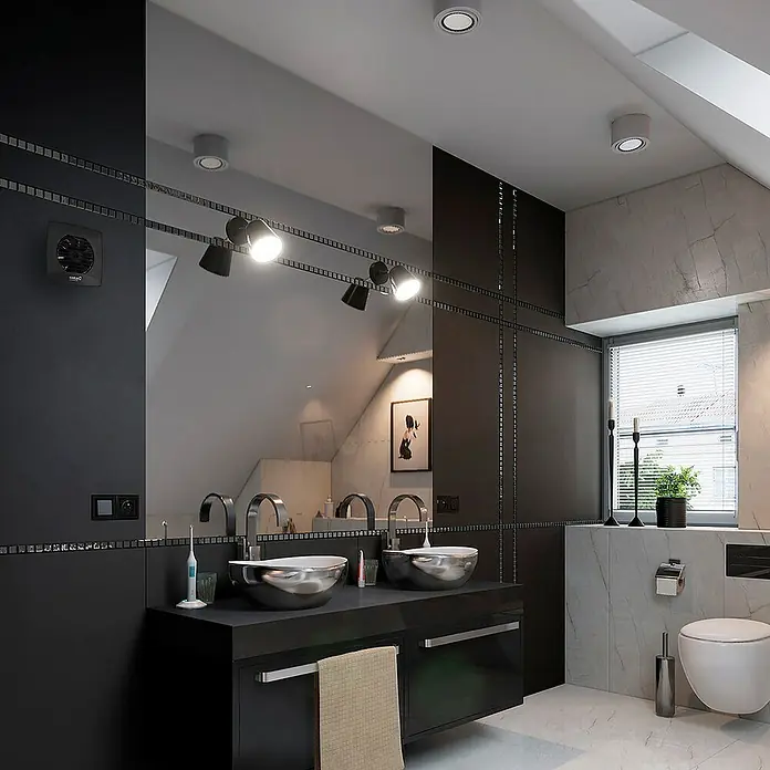 Cata Ventilador de pared UC-10 HYGRO - Negro, 9,8 cm - Un baño moderno con lavabo doble, lavamanos redondos y accesorios oscuros bajo una superficie espejada.