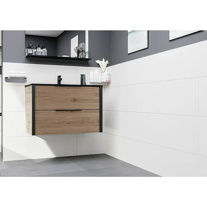 Ambiente by Palazzo Wandfliese Snowwhite - 30 x 90 cm, Weiß, Matt - Modernes Badezimmer mit Waschtischunterschrank in Holzoptik mit zwei Schubladen und schwarzem Rahmen. Helle Fliesen und grauer Boden ergänzen das Design.