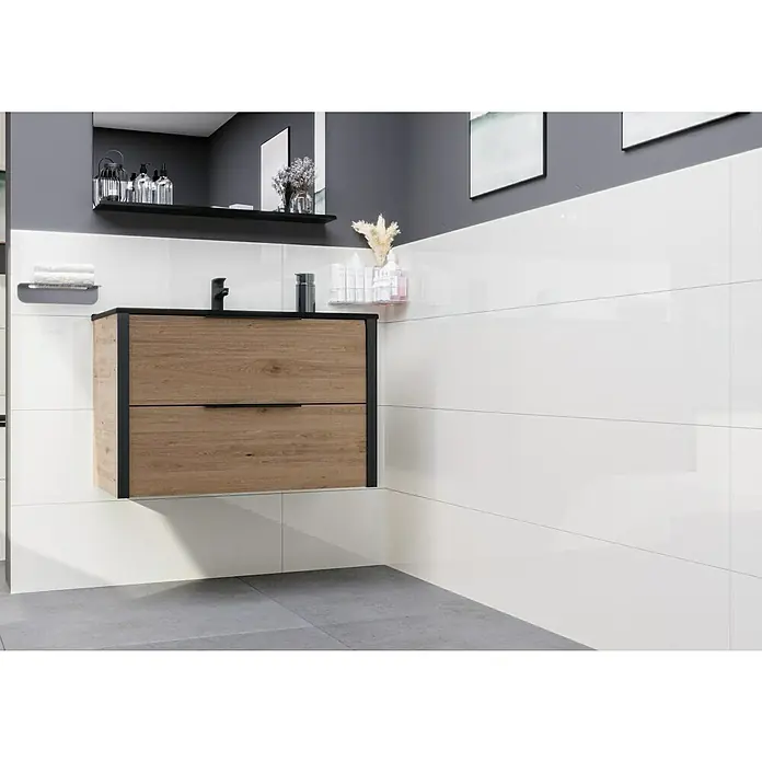 Ambiente by Palazzo Wandfliese Snowwhite - 30 x 90 cm, Weiß, Glänzend - Ein modernes Badezimmer mit einem Waschtisch aus hellem Holz und schwarzen Akzenten vor einer weißen Wand.