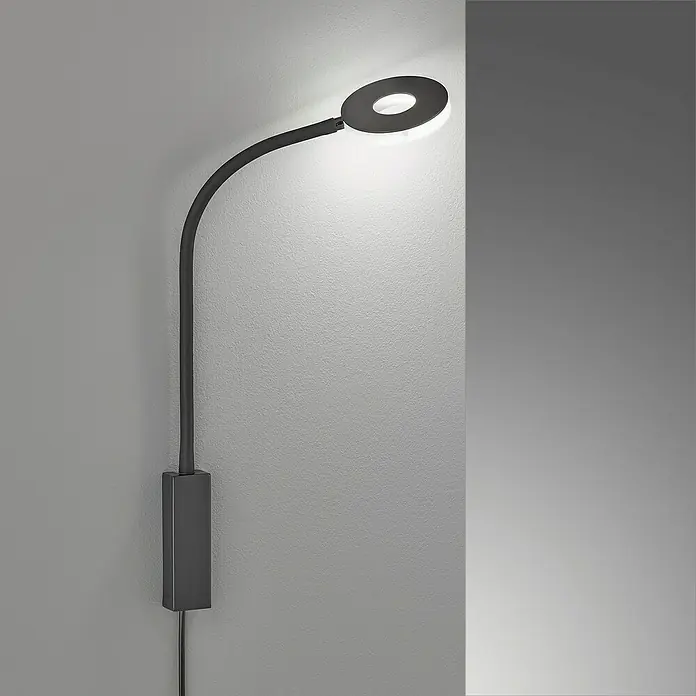 Fischer & Honsel LED-Wandleuchte Cama - 6 W, L x B x H: 35 x 10 x 50 cm, Sandschwarz, Warmweiß - Nahaufnahme einer modernen, grauen LED-Wandleuchte mit flexiblem Arm und kreisförmigem Kopf, die ein helles, weißes Licht ausstrahlt.