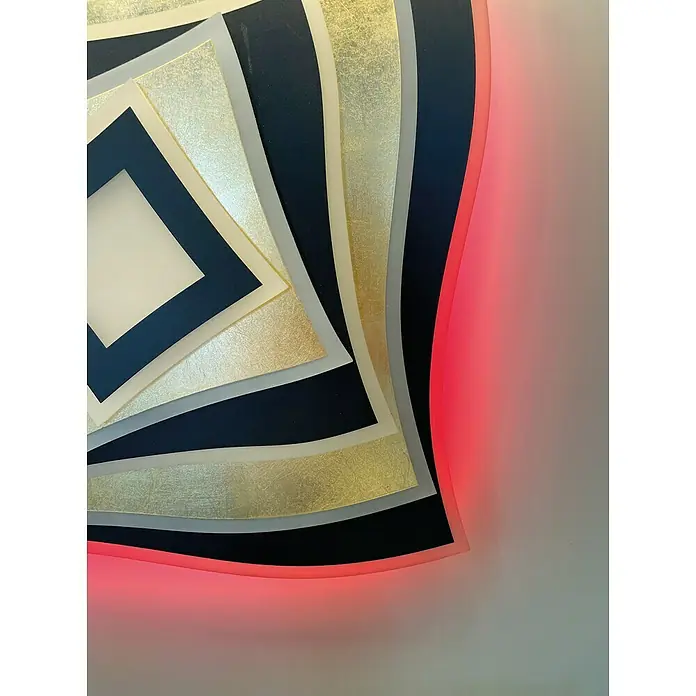 Fischer & Honsel LED-Deckenleuchte Hero - 50 W, L x B x H: 50 x 50 x 7,6 cm, Gold/Sandschwarz, Mehrfarbig - Nahaufnahme einer modernen Wandkunst mit geometrischen Formen in Schwarz, Gold und Grau, die von einem subtilen roten Licht akzentuiert werden.