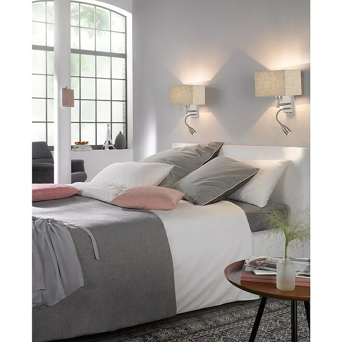 Fischer & Honsel Wandleuchte Dream - 44 W, L x B x H: 20 x 25 x 38 cm, Nickel, Sand, E27 - Modernes Schlafzimmer mit zwei Wandleuchten über dem Bett, die ein warmes Licht spenden, und einem Beistelltisch mit Dekorationen.