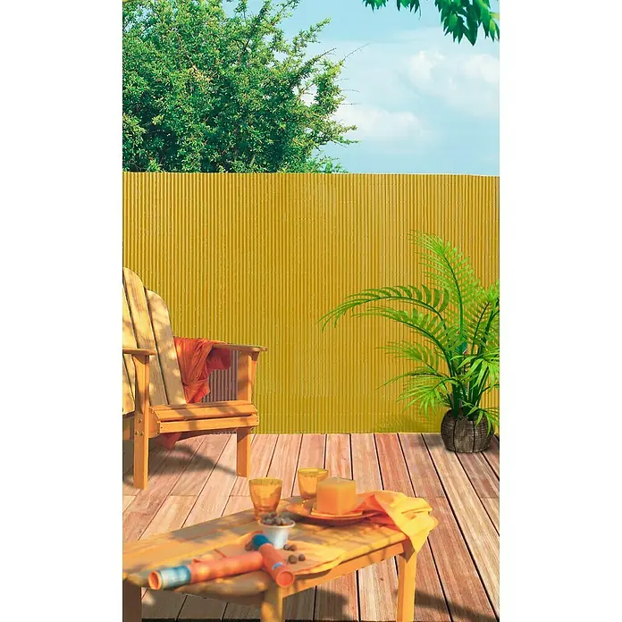 Nortene Ocultación Cañizo Plasticane Semi-oval - Arena, L x Al: 3 x 1 m - Un panel de cerca amarillo corrugado en un patio con muebles de exterior, ideal para la privacidad y como elemento decorativo en el área exterior.