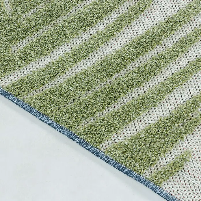 Outdoor-Teppich Bahama VIII - Grün, 200 x 140 cm, 100 % Polypropylen - Detailansicht eines Teppichs mit grün-weißem Streifenmuster und blauem Rand, der eine weiche Textur und ein dekoratives Design zeigt.
