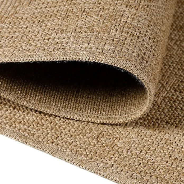 Outdoor-Teppich Dhaka V - Beige, 150 x 80 cm, 100 % Polypropylen - Nahaufnahme eines gerollten Teppichs mit gewebter Textur in natürlichen Farbtönen, der Wärme und Komfort ausstrahlt.