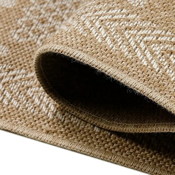 Outdoor-Teppich Dhaka I - Beige, 250 x 80 cm, 100 % Polypropylen - Detailaufnahme eines gewebten Teppichs mit beigem Muster und aufgerolltem Rand, der die Textur hervorhebt.