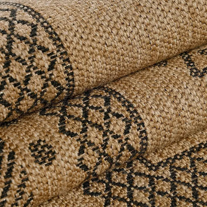 Outdoor-Teppich Dhaka I - Schwarz, 200 x 140 cm, 100 % Polypropylen - Nahaufnahme eines gewebten Teppichs mit einem komplexen geometrischen Muster in Schwarz auf einem braunen Hintergrund.