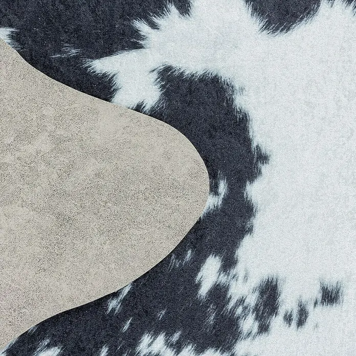 Flachgewebeteppich Etosha - Kuh, Schwarz/Weiß, 200 x 150 cm, 100 % Polyester - Nahaufnahme einer Kuhfell-Teppichrückseite, die die Detailgenauigkeit und die hochwertige Verarbeitung des Teppichs hervorhebt.