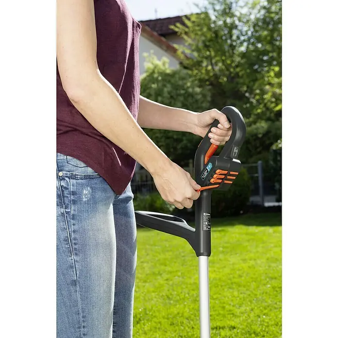 Gardena SmallCut Akku-Rasentrimmer Li-23 R - 14,4 V, 2 Ah, Li-Ionen, 1 Akku, Schnittbreite Messer: 22,3 cm - Eine Person bedient einen Gardena Akku-Rasentrimmer, um den Garten zu pflegen. Das Gerät ist ergonomisch gestaltet und benutzerfreundlich.