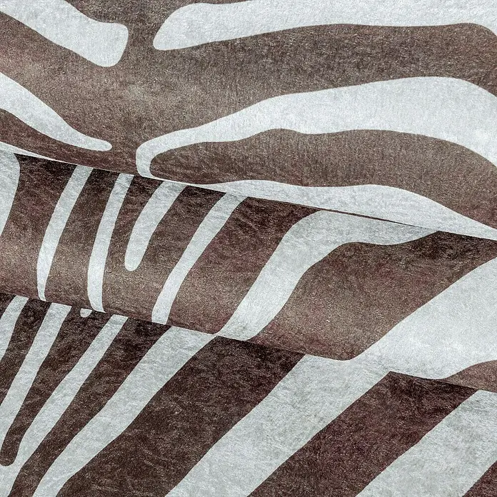 Flachgewebeteppich Etosha - Zebra, Braun, 135 x 100 cm, 100 % Polyester - Nahaufnahme eines Stoffes mit Zebra-Muster in Braun- und Weißtönen, der eine stilvolle und wilde Note verleiht und sich ideal für kreative Projekte eignet.
