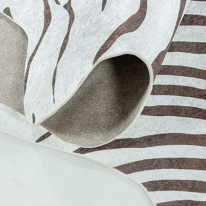 Flachgewebeteppich Etosha - Zebra, Braun, 135 x 100 cm, 100 % Polyester - Nahaufnahme eines stilvollen Teppichs mit auffälligem Zebra- und Streifenmuster, der eine moderne und wilde Note versprüht.