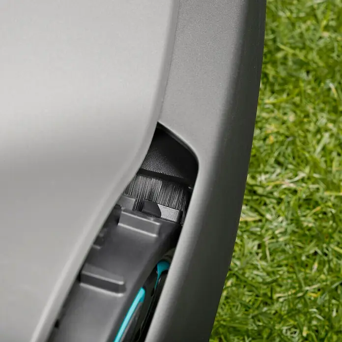 Gardena Rasenmäherbürste Sileno City - Passend für: Gardena Mähroboter SILENO City-Serie - Detailansicht eines Mähroboters mit Bürsten und Abdeckung, der auf einem Rasen steht. Präzise Rasenpflege leicht gemacht.