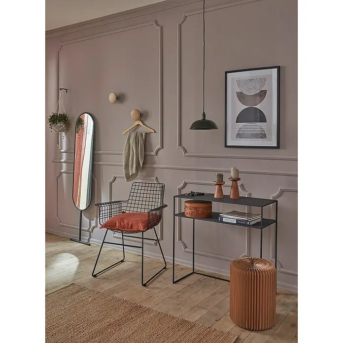 Nmc Decoflair Eckelement Eckteil Viertelbogen für Wandleiste - 4 Stk., Passend für: Nmc Decoflair Zierprofil Wandleiste CL1 - Einrichtungsidee mit einem schwarzen Gitterstuhl mit orangefarbenem Kissen, einem schwarzen Konsolentisch und einem Spiegel vor einer Wand mit Zierleisten.