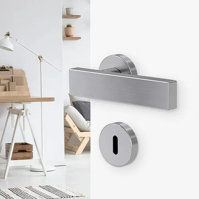 Diamond Doors Modern Zimmertürgarnitur Cube - Edelstahl, Buntbart - Das Bild zeigt eine moderne Türgarnitur aus Edelstahl mit einem markanten, rechteckigen Griff und einem runden Schlüsselloch.