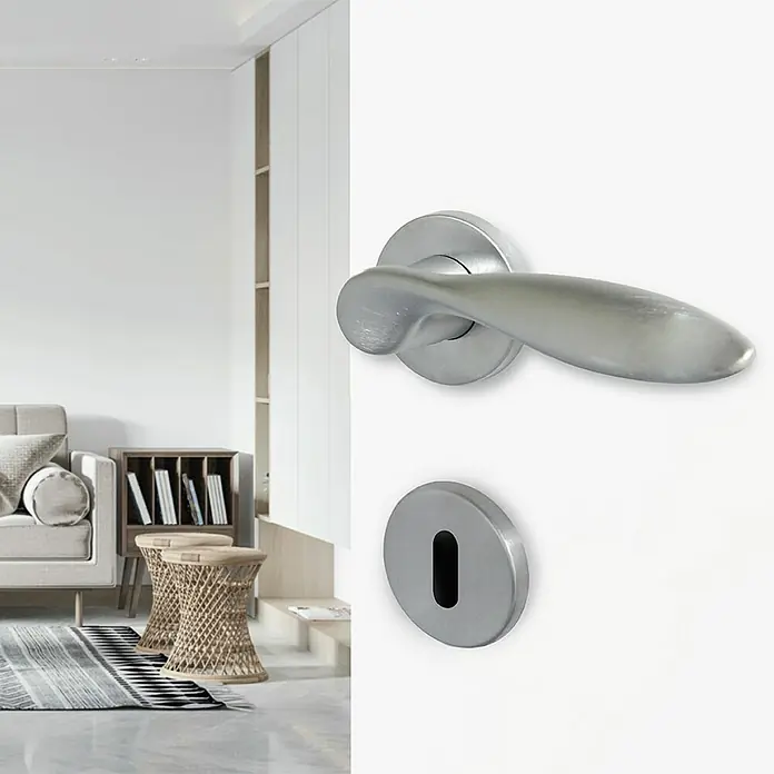 Diamond Doors Creative Zimmertürgarnitur Sunnyvale - Stärke Tür: 40 mm - 45 mm, Chrom matt, Buntbart - Nahaufnahme einer modernen, silberfarbenen Türklinke mit Schlüsselloch in einem hellen, minimalistischen Interieur.