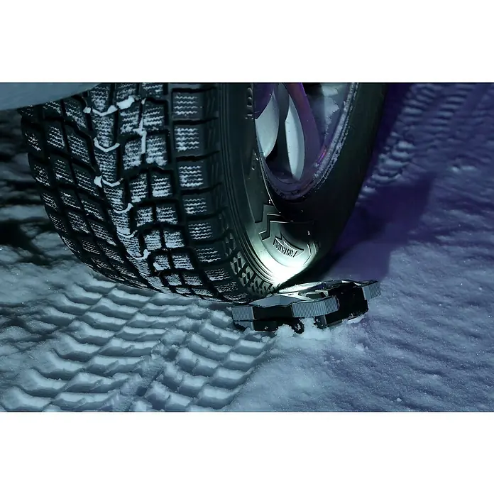 Brennenstuhl Mobiler LED-Strahler Rufus - Akkubetrieben, 30 W, L x B x H: 5 x 14 x 21 cm, IP65 - Nahaufnahme eines Reifens mit Schneeketten auf Schnee.